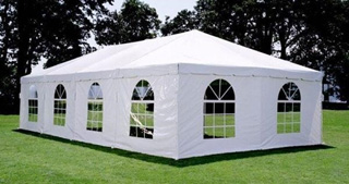 white event tent with windows set up on grass